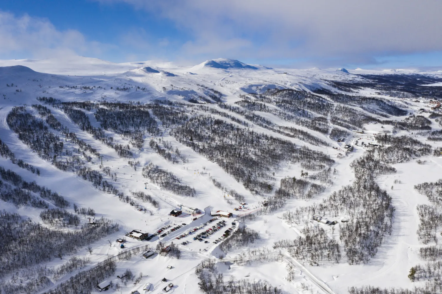 Ett snötäckt berg med en by och skidbackar