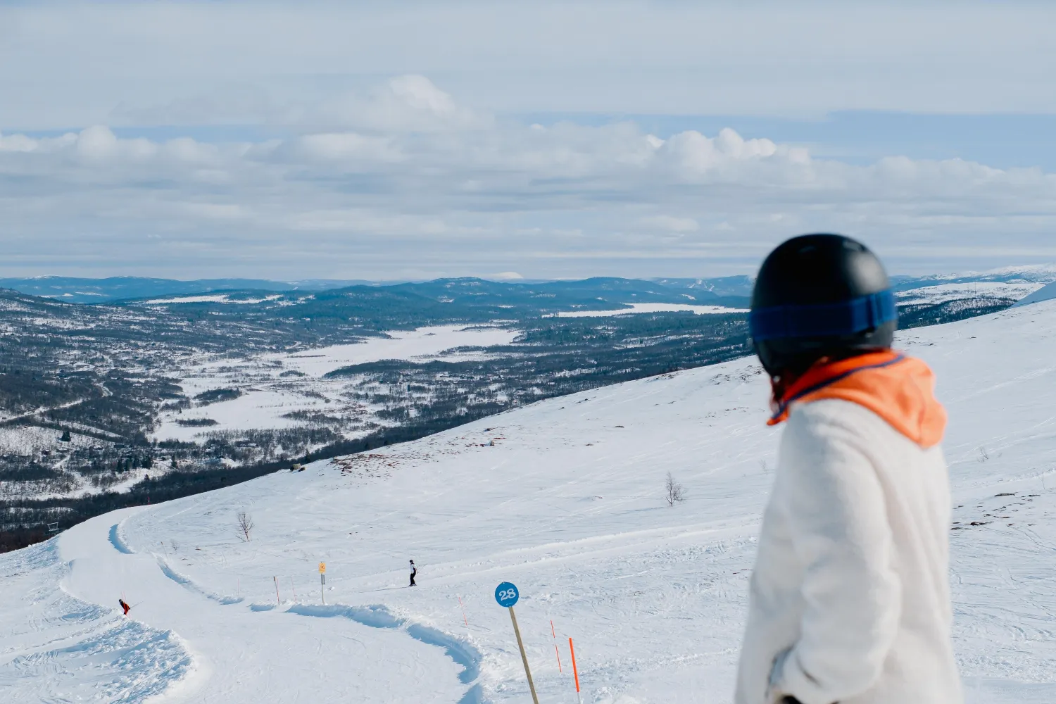 en person på ett snötäckt berg som tittar på ett landskap