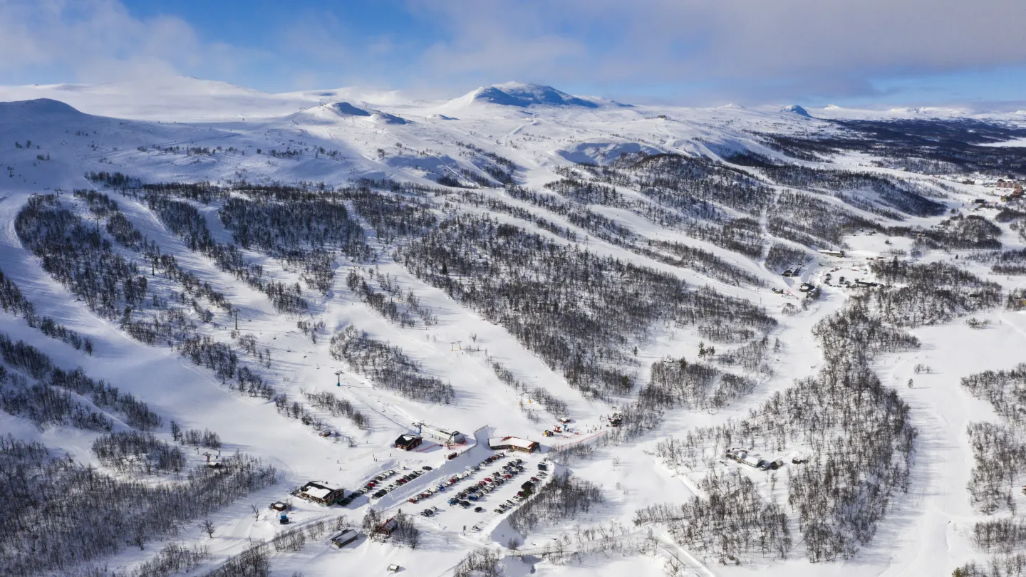 Ett snötäckt berg med en by och skidbackar